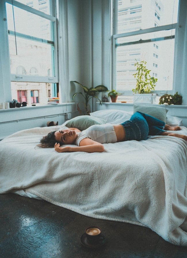 mujer jóven pensando en la cama