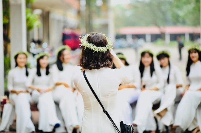 Mujeres sentadas todas vestidas de blanco