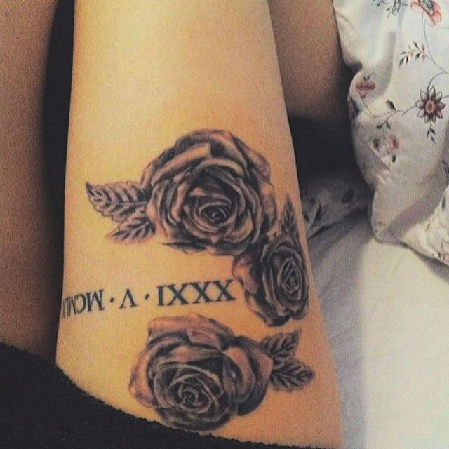 Chica con varios números romanos en la pierna junto a dos rosas de gran tamaño. Es uno de los tatuajes más sexys que hemos visto en este artículo.