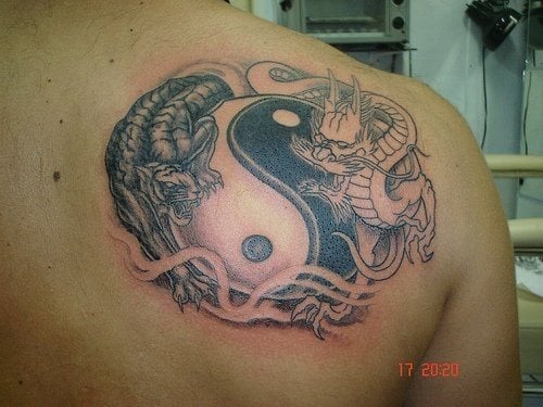 Un dragón blanco y otro negro rodeando el símbolo. El animal de la izquierda es una pantera.