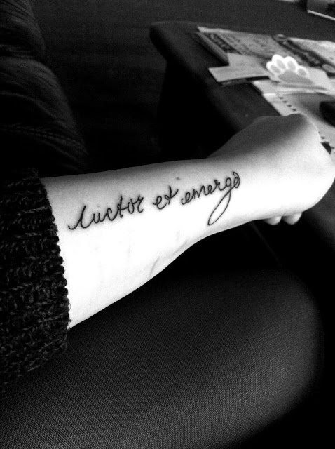 Tatuaje en el brazo con la frase luctor et emergo, ha sido trazado con finas líneas y una tipografía clásica, donde la letra 