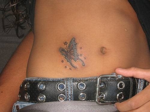 Para este primer tatuaje de la galera tenemos a una chica que nos ensea un bonito tatuaje al lado de su ombligo de una mariposa con unas pequeas estrellas a su alrededor