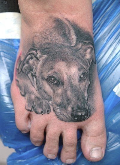 Tatuaje de la cabeza de un perro que cubre todo el empeine