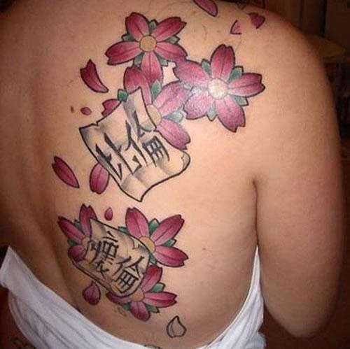 Para empezar esta extica galera, aqu encontramos un tatuaje en el lado derecho de la espalda compuesto por un par de palabras en chino escritas sobre un papel que vuela con unas flores de cerezo, algo tpicamente asitico