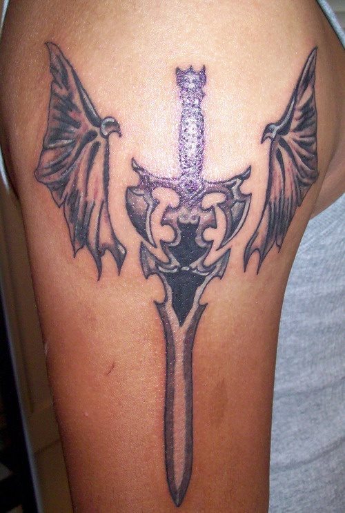Gran diseo de una espada con alas en los laterales tatuada en el brazo