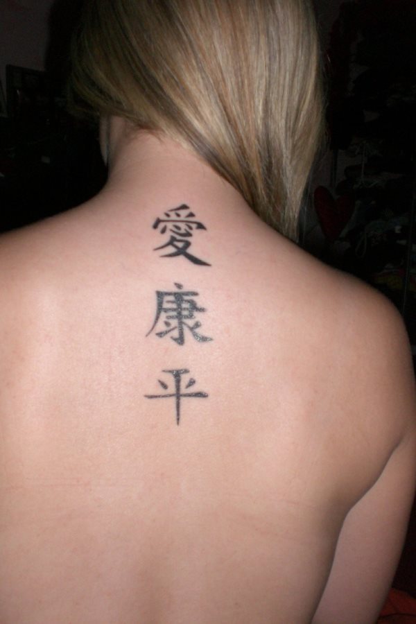 Esta chica nos muestra su tatuaje vertical en el centro de la parte superior de la espalda