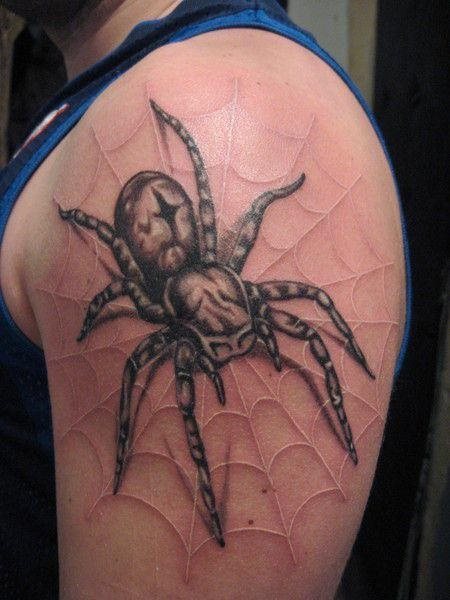 Otro diseo que parece muy real, sobre el brazo, la tela de una araa con el arcnido encima