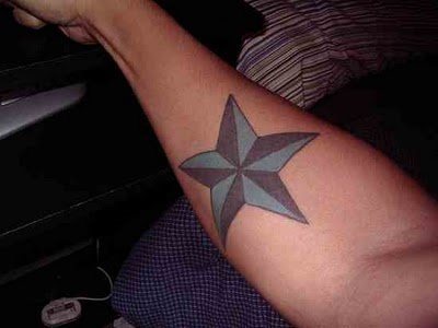 Diseo de una estrella en tonos azules y negros en el antebrazo de este joven