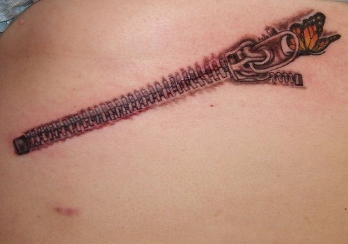 En esta ocasin, esta persona ha decidido tatuarse una cremallera acabando de ser cerrada por una pequea mariposa