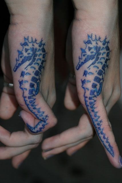 Azulados caballitos de mar en el lateral de la mano