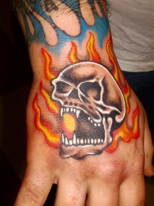 Un crneo o una calavera en llamas tatuada sobre la mano