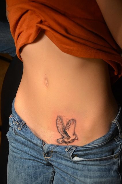 El tatuaje de esta chica es el de un pjaro volando, realizado a tinta negra