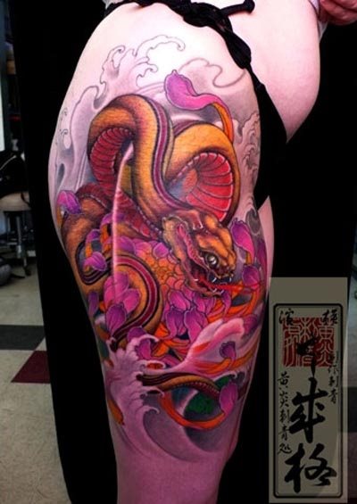 Esta chica se ha tatuado una gran escena cuyo motivo principal es una gran serpiente en tonos anaranajados y rosados