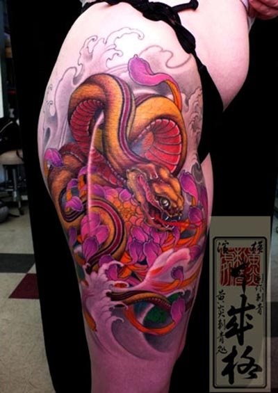 Esta chica se ha tatuado una gran escena cuyo motivo principal es una gran serpiente en tonos anaranajados y rosados Esta chica se ha tatuado una gran escena cuyo motivo principal es una gran serpiente en tonos anaranajados y rosados