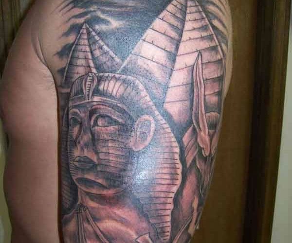 Bonito tatuaje de un faran con pirmides al fondo tatuado sobre el brazo