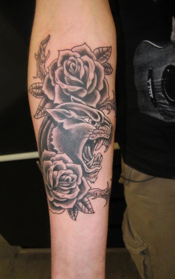 En esta imagen podemos ver un tatuaje de una rosa acompaada por la cabeza de un animal, que puede que se trate de un puma