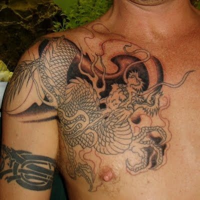 Tatuaje de un dragón asiático a color negro que cubre toda la parte derecha del pecho, recorriendo el hombro hasta acabar el bíceps
