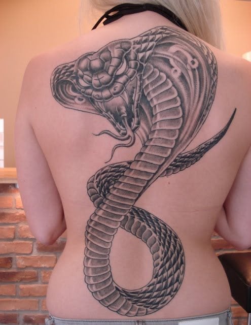 Una gran serpiente cobra tatuada en toda la espalda