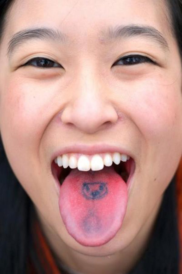 La cabeza de un pequeño animal es el tatuaje elegido por esta chica para dibujar en su lenga, en tonos azulados, como podemos observar es de pequeño tamaño y se ha escogido una parte difícil del cuerpo