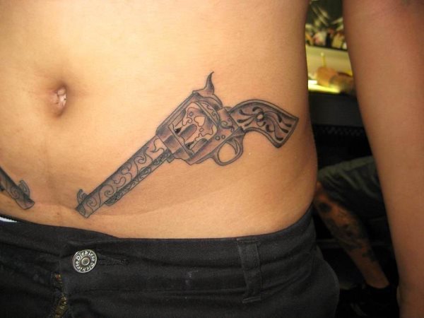 Esta chica lleva dos pistolas tatuadas a ambos lados del abdomen