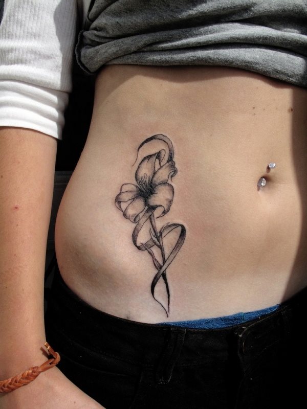 Esta chica luce un bonito tatuaje en blanco y negro de una flor de lirio
