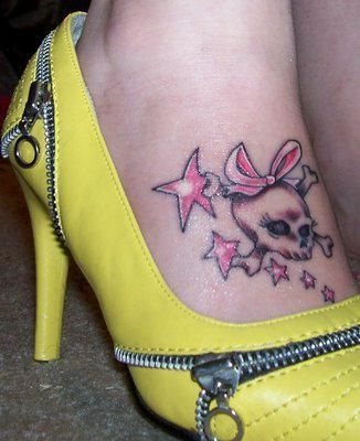 Calavera muy femenina en tonos rosados y con un lazo en la cabeza que le dan ese aire infantil a la par que alocado al tattoo, las estrellas combinan perfectamente por su color y su tamaño con las calaveras