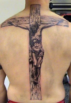 Gran cruz tatuada sobre la espalda con Jesús crucificado impregnando un gran realismo no sólo por su tamaño, sino también por el realismo del Hijo de Dios crucificado y la cruz de madera con unas betas de madera muy bien conseguidas, al igual que las sombras del Señor