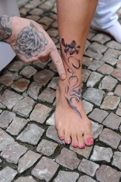 Sencillo tatuaje con motivos florales sobre el empeine de esta chica, tal vez nos llame más la atención el espectacular tatuaje en la mano de la otra persona, pero sin duda el del pie de esta chica, también es un buen tatuaje