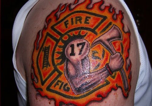 Diseo de ujn smbolo con el nmero 17 sobre un brazo con un hacha y a su vez sobre un fondo en llamas con las palabras fire fighter, en castellano bombero