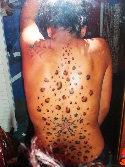 Diseo de piel de leopardo tatuado sobre la espalda, aunque da la sensacin de que estn cayendo desde la parte de la nuca hacia abajo de manera desordenada