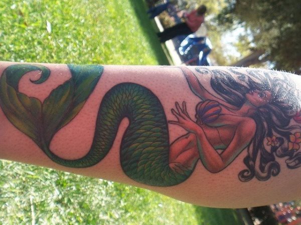 Sirena con grandes curvas y tatuada en el gemelo