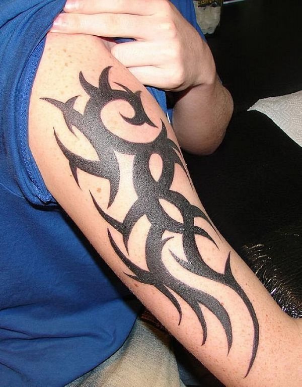 Tatuaje tribal de gran tamaño en el brazo, en el que destacamos la anchura de las ramas que componen el tatuaje, un buen tattoo para todos aquellos a los que le gusten los tribales