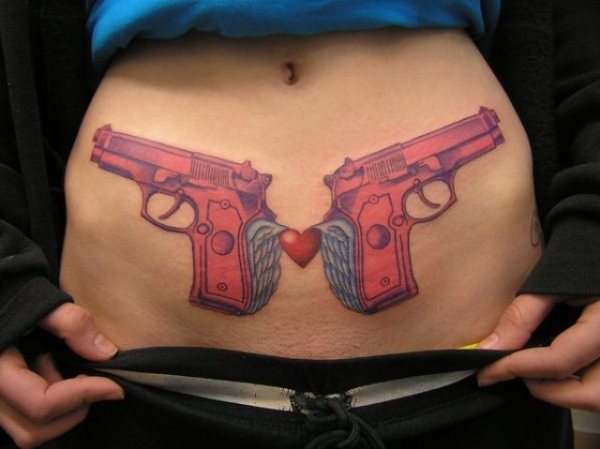 Tatuaje de dos pistolas aladas unicas por un pequeño corazón en rojo, la verdad es que nos cuesta trabajo comprender como se pueden unir la guerra y el amor, pero en esta ocasión se ve que esta chica ha intentado conseguirlo