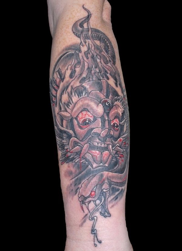 Tatuaje de demonio que ocupa todo el antebrazo y para el que se ha utilizado el color negro en su mayoría y el rojo para algunos detalles como las venas de los ojos y la lengua, dando así una mayor expresión de nerviosismo a todo el tatuaje, en el que además podemos apreciar unas pequeñas flechas y una gran cola que sube un poco hasta llegar a parte del bíceps, que tattoo tan completo para ocupar una parte del cuerpo que no es precisamente demasiado grande