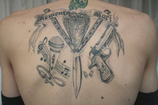 Varios motivos componen este tatuaje, la pistola, un micrfono y una gran cobra en el centro