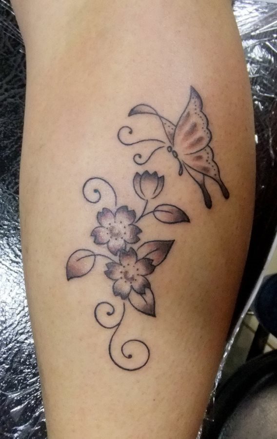 Esta persona se decidi por un tatuaje de flores acompaadas por una mariposa a punto de posarse