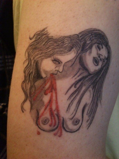 Tatuaje de dos mujeres vampíricas, que están desnudas y se puede ver como una mujer está mordiendo con sus colmillos en el cuello de la otra mujer, a la que le brota sangre de la herida que le está produciendo
