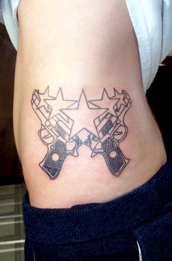 Tatuaje de la silueta de dos pistolas y sobre ella se han tatuado cinco estrellas, en la que la de en medio es de mayor tamaño que el resto de estrellas