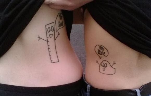 Tatuaje simpático de parejas, uno de ellos se ha tatuado una regla con un bocadillo y en su interiro la misma frase, que la otra persona también se ha tatuado en el interior del bocadillo, pero ha optado por otro muñeco en vez de por una regla