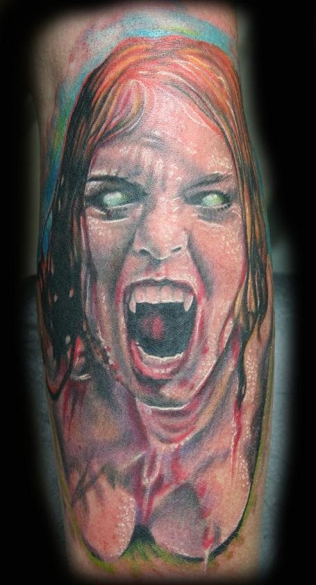 Tatuaje de una mujer vampira con los ojos y colmillos caracterísiticos de estos seres y en cuyo tatuaje se ha realizado una buena mezcla de colores, consiguiendo un aspecto muy favorable, además resaltar el buen juego del color blanco para hacer arrugas en la cara y conseguir el brillo adecuado