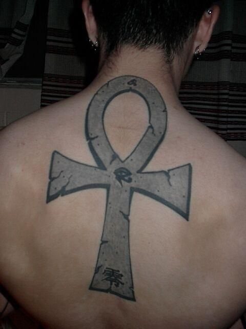 Gran cruz egipcia tatuada sobre la espalda