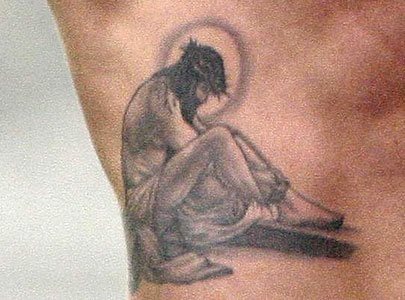 Tatuaje de Cristo sentado y al que se le ha añadido la sábana que le cubría, la corona de espinas y a la vez ese halo espiritual que envuelve a todas las personas santas, un tatuaje diferente para los cristianos, que nos gusta bastante