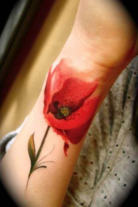 Este precioso y realista tatuaje situado en el antebrazo es de una amapola de un color rojo intenso que en su parte superior acaba difuminndose sutilmente hasta fundirse con el color de la piel