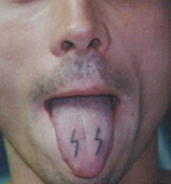 Tatuaje en la lengua de dos pequeñas líneas que parecen truenos y que le dan un aspecto excesivamente peculiar a la lengua de este chico, del que suponemos tendrá ya varios tatuajes y por eso ha buscado una zona nueva para hacerse este tattoo en la lengua