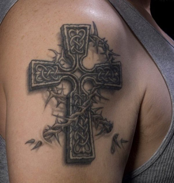 Diseño de una cruz entre espinas tatuado en el brazo, tal vez un tatuaje que necesitaría ser retocado un poco más para destacar algunas facciones tan bien conseguidas como es el interior de la cruz tallada  