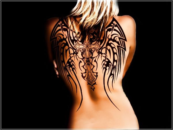 Tatuaje en la espalda de una cruz a la que se le han tatuado unas enormes alas tribales, el tatuaje parece no ser de verdad, sino que ha sido elaborado con algún programa de tratamiento digital de las fotografías, pero sin duda, es una buena idea de tattoo