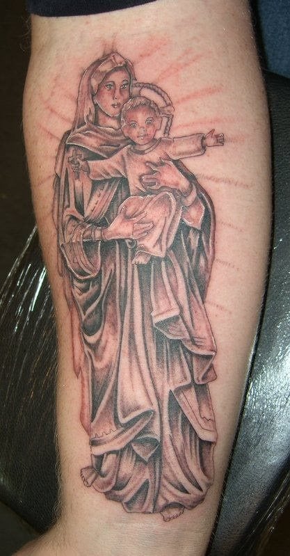 Tatuaje de la Virgen María que tiene a su hijo sobre sus manos, al que se le ha añadido el color negro a su piel, un precioso y original tatuaje para todos aquellos creyentes que quieran llevar a Dios siempre en su piel