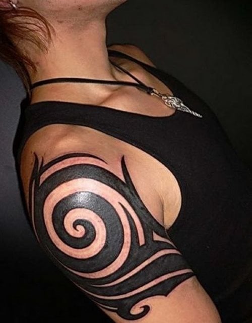 Bonito tatuaje tribal circular en el que han elegido una buena parte para darle ese aspecto circular, que parece fundirse con el hombro y conforman un buen tatuaje tribal, que parece ser de gran gusto por el tatuado, que como vemos, hasta lleva un colgante de estilo tribal