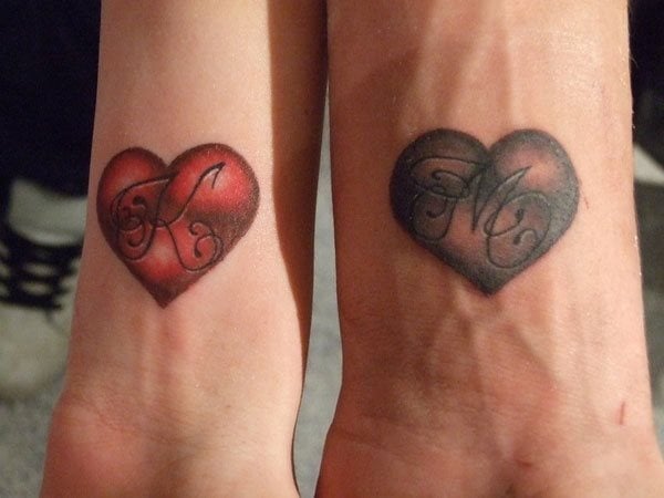 Tatuaje de pareja, ella en la muñeca lleva un corazón con la inicial 