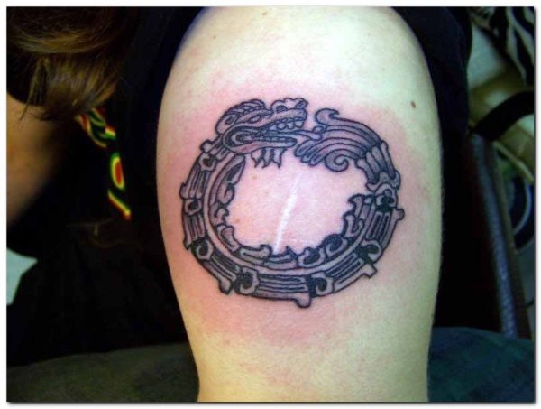 Dragn azteca tatuado en el brazo de una mujer joven